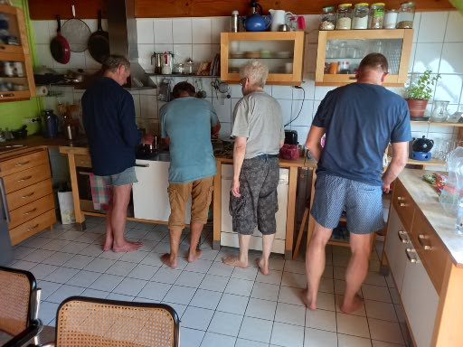 Vier Männer bereiten in der Küche gemeinsam das Mittagessen zu